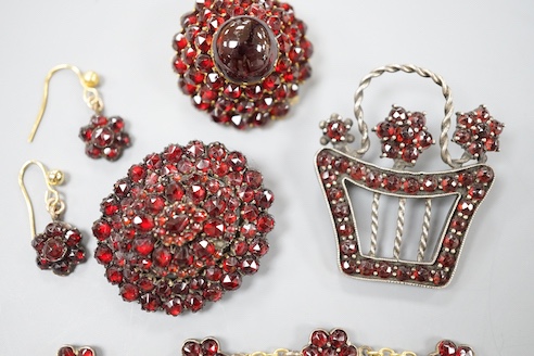 A Victorian gilt metal and facetted garnet set cluster brooch, 27mm, two other similar brooches, a bracelet and pair of earrings.